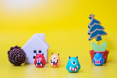 Close-up of toys on table against yellow background