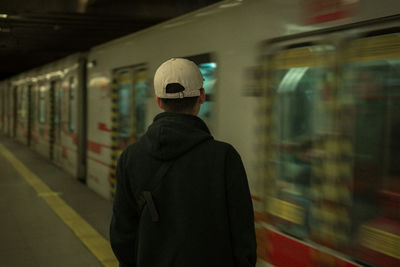 Rear view of man standing at railroad station