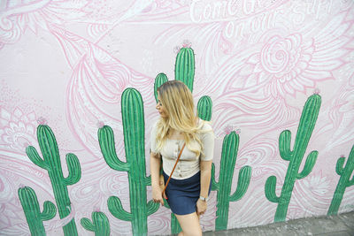 Rear view of woman standing against wall