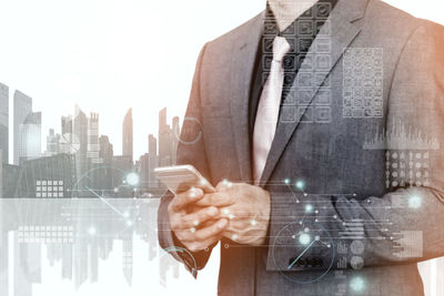 Digital composite image of businessman using mobile phone