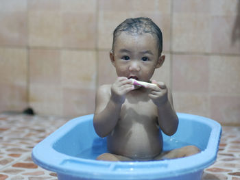 Portrait of cute baby boy in bathroom