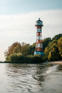 Lighthouse by lake against sky