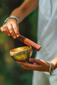 Hands of a woman playing tibetan singing bowl in nature