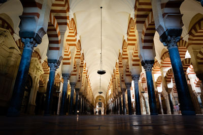 Low angle view of illuminated lights hanging on ceiling of building