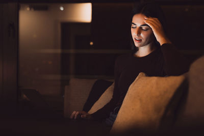 Portrait of young woman sitting at home