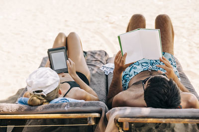 Rear view of friends relaxing on laptop