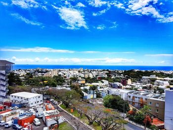 High angle view of townscape by sea against sky