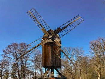 Low angle view of traditional windmill against clear blue sky