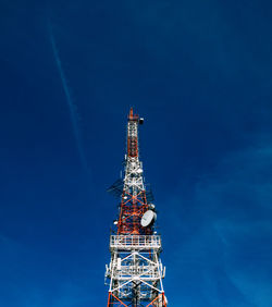 Low angle view of communications tower against blue sky