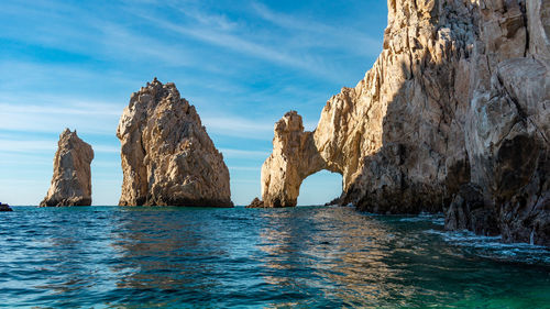 Panoramic view of rock formation in sea against blue sky