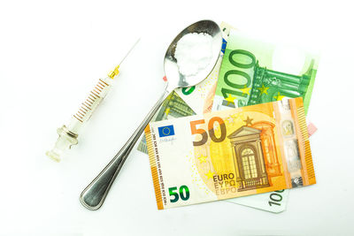 High angle view of coins on white background