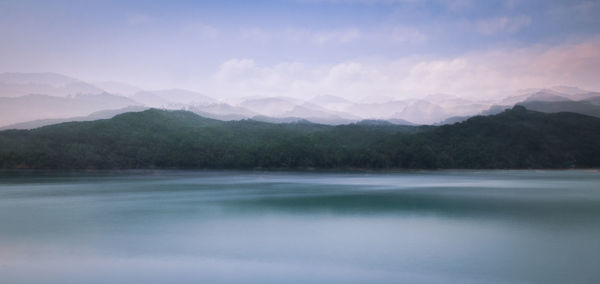 Scenic view of lake and mountains against sky