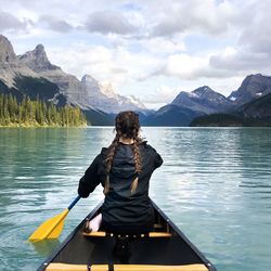 Rear view of woman in boat in lake