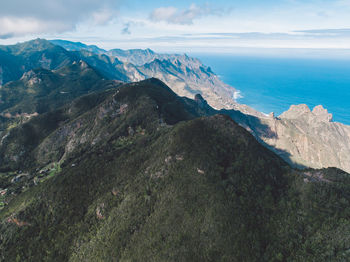 Scenic view of sea and mountains against sky