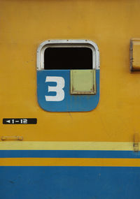 Close-up of yellow arrow sign on wall
