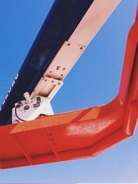 Low angle view of red wall against clear blue sky