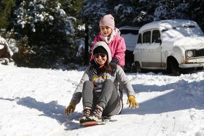 Rear view of women on snow covered landscape during winter