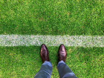 Low section of man standing on field