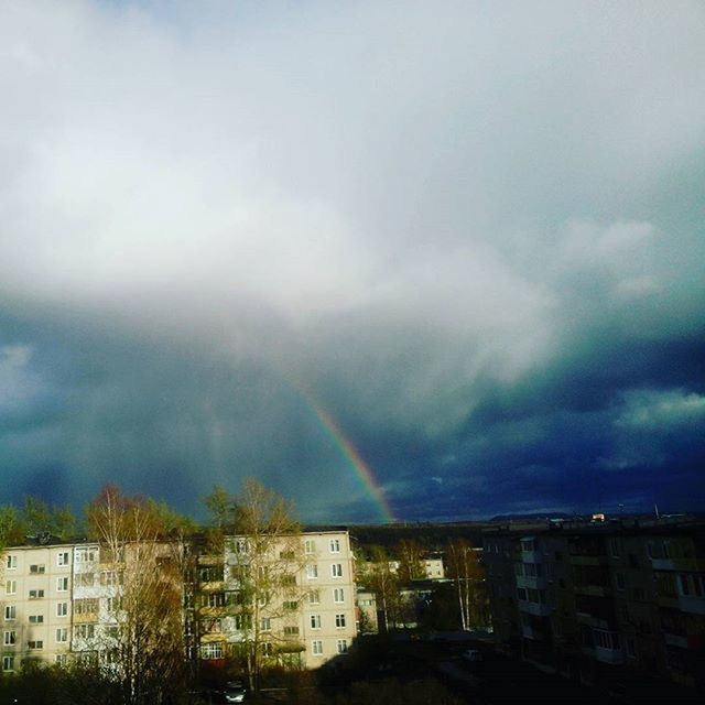 building exterior, architecture, built structure, sky, rainbow, cloud - sky, city, cloudy, weather, storm cloud, residential district, residential building, cityscape, residential structure, overcast, house, multi colored, cloud, dusk, tree