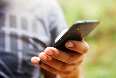 Midsection of man using mobile phone outdoors