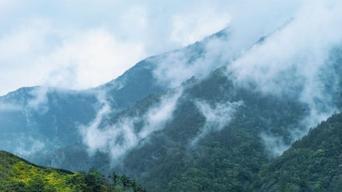 Scenic view of cloud flow over the mountains against sky