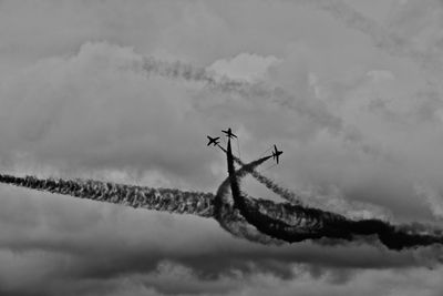 Low angle view of airplane against cloudy sky