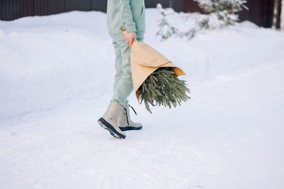 Happy couple playing winter game in forest outdoors. boyfriend gives girlfriend bouquet 