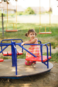 Girl playing on carousel at playground