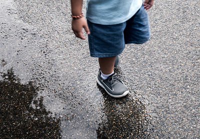 Low section of man standing on road