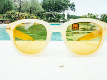 Close-up of sunglasses on table by swimming pool
