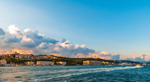 Scenic view of sea by buildings against sky