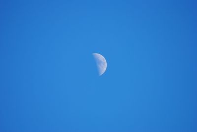 Low angle view of crescent moon against clear blue sky at dusk