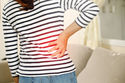 Midsection of woman standing against wall