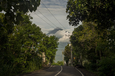 Road amidst trees against sky