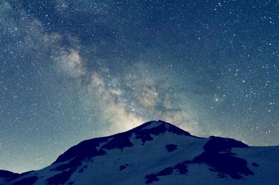 Scenic view of snowcapped mountain against sky at night