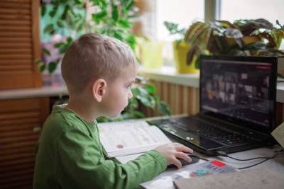 Boy learning through laptop at home