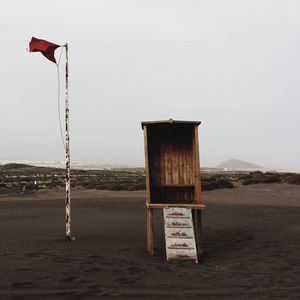 Wooden posts on beach against clear sky