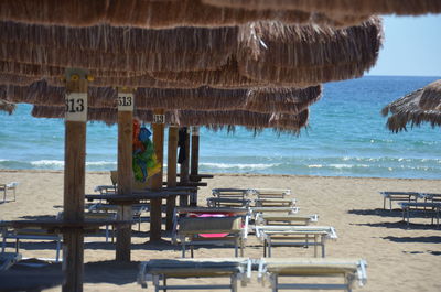 Chairs on beach against sky