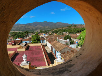 Panoramic view of townscape against sky seen through window