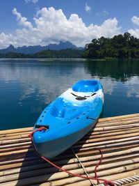Blue kayak moored on wooden raft over lake