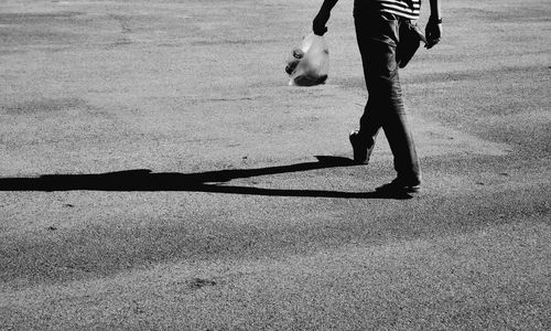 Low section of man playing with umbrella