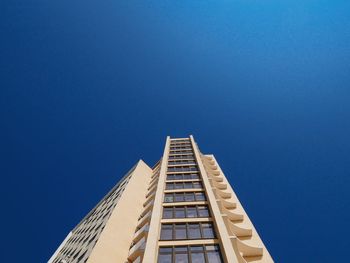 Low angle view of modern building against clear blue sky