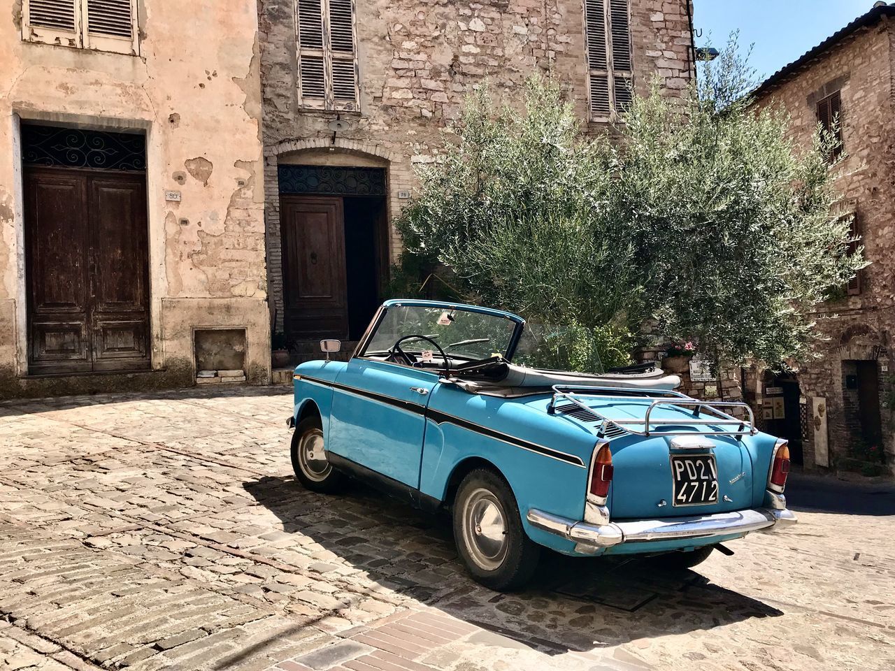 VINTAGE CAR ON STREET AGAINST BUILDING