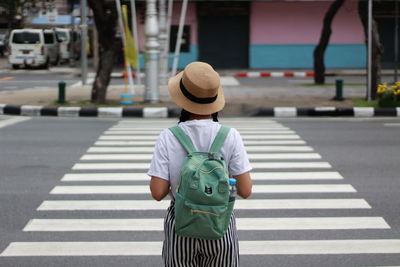 Rear view of man crossing road