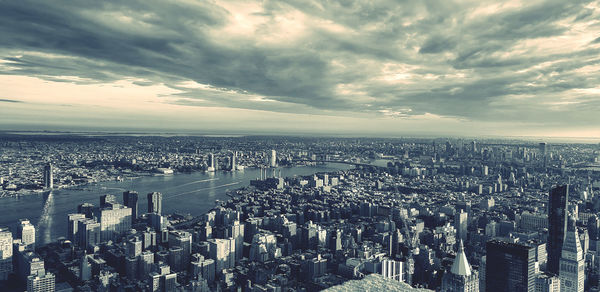 High angle view of city buildings against cloudy sky