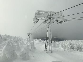 Ski lift on snow field against sky