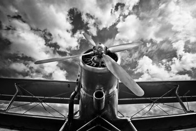 Low angle view of airplane against cloudy sky