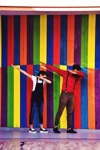 People standing against multi colored wall