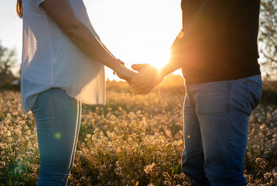 Midsection of couple standing on field