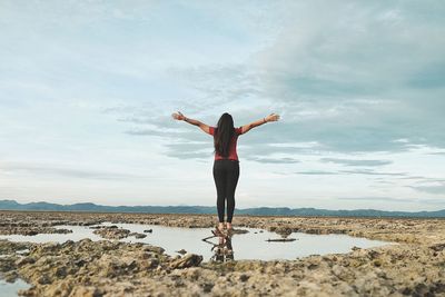 Silhouette of woman standing against cloudy sky